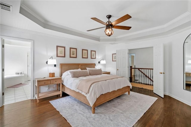 6219 Creekstone Path, Cumming, GA 30041 - bedroom with a raised ceiling, dark wood-type flooring, crown molding, connected bathroom, and a ceiling fan