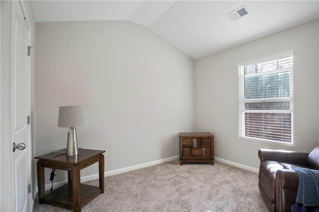 sitting room with vaulted ceiling, baseboards, visible vents, and light carpet