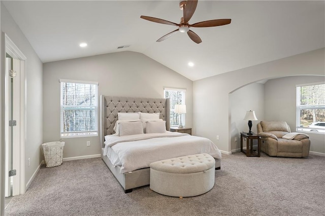 carpeted bedroom with visible vents, multiple windows, and vaulted ceiling