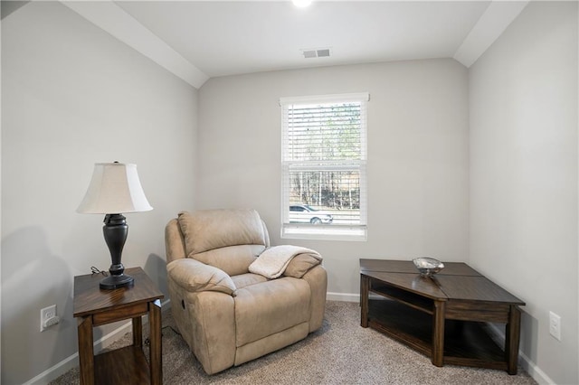 living area with vaulted ceiling, light colored carpet, visible vents, and baseboards