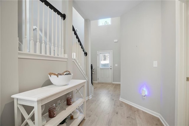 entrance foyer with light wood finished floors, stairs, and baseboards