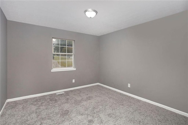 carpeted empty room with visible vents and baseboards