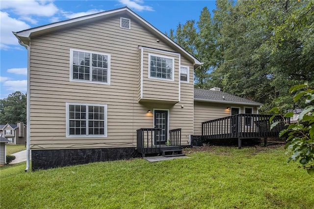 back of property featuring a lawn and a wooden deck