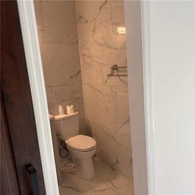 bathroom with tile walls and toilet