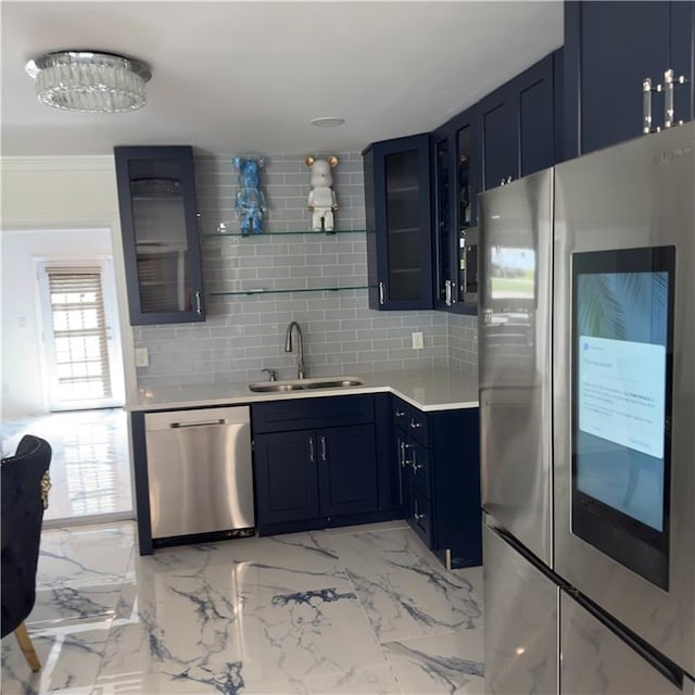 kitchen with decorative backsplash, crown molding, blue cabinetry, sink, and stainless steel appliances