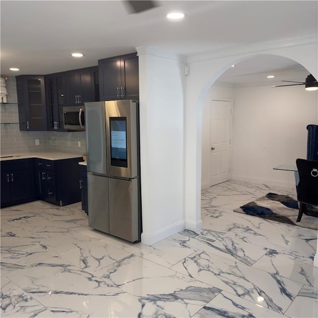 kitchen featuring decorative backsplash, crown molding, appliances with stainless steel finishes, and ceiling fan