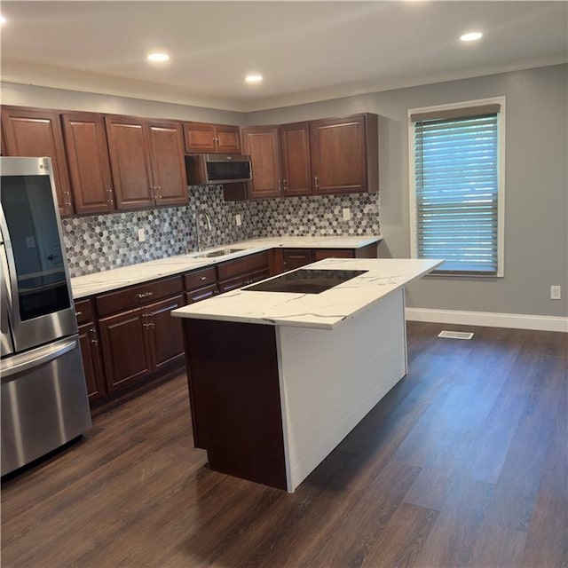 kitchen featuring sink, appliances with stainless steel finishes, dark hardwood / wood-style flooring, and a kitchen island