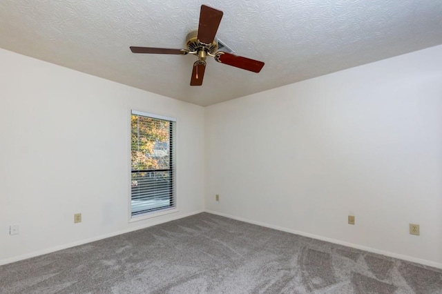 carpeted spare room with ceiling fan, a textured ceiling, and baseboards