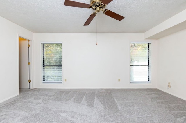 spare room with a textured ceiling, a healthy amount of sunlight, and carpet flooring