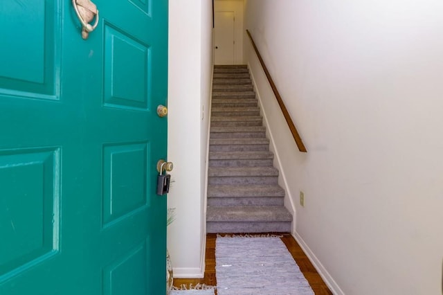 stairs with wood finished floors and baseboards