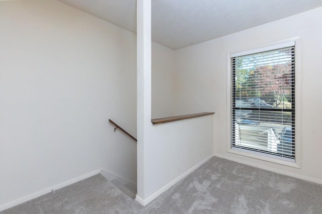 interior space with baseboards, carpet, and a textured ceiling