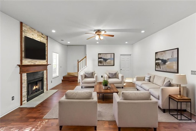 living room featuring recessed lighting, dark wood-style floors, and a large fireplace