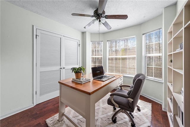 office area with baseboards, a textured ceiling, dark wood finished floors, and a ceiling fan