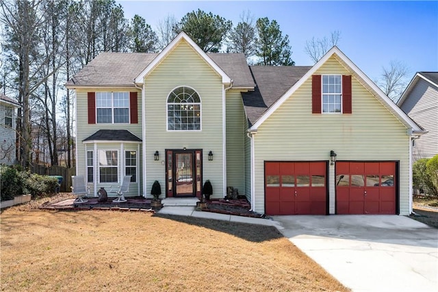 view of front of home with driveway, a front yard, and a garage