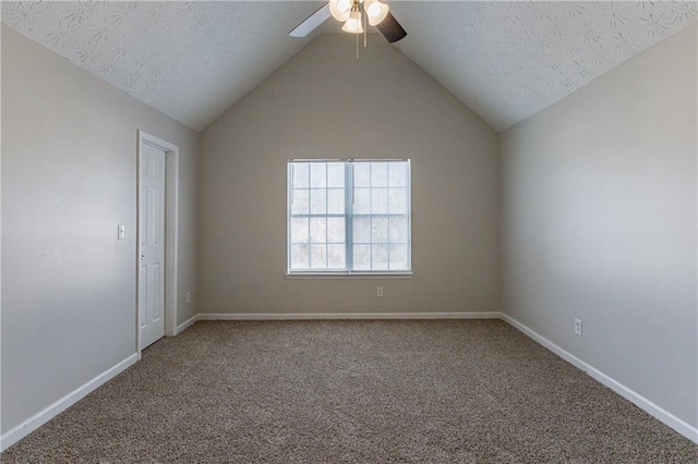 carpeted empty room with ceiling fan, a textured ceiling, and vaulted ceiling