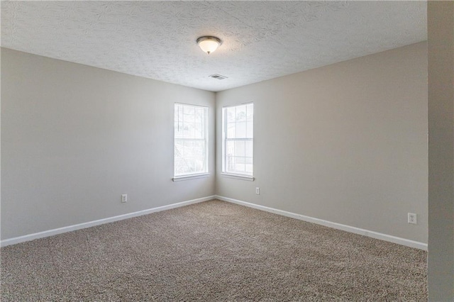 unfurnished room featuring a textured ceiling and carpet flooring