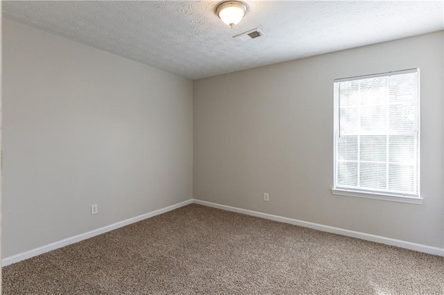 carpeted spare room featuring a textured ceiling