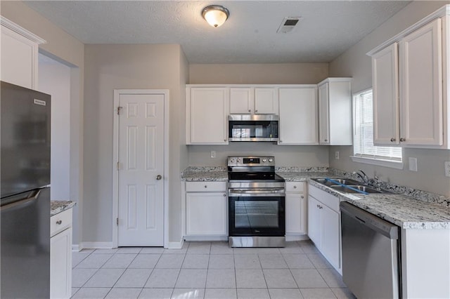 kitchen with appliances with stainless steel finishes, white cabinets, and sink