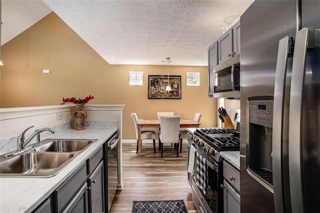 855 Lakeside Cir, Covington, GA 30016 - kitchen featuring stainless steel appliances, a sink, wood finished floors, a textured ceiling, and light countertops