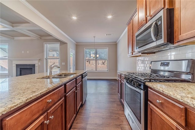 kitchen with a sink, tasteful backsplash, stainless steel appliances, a fireplace, and crown molding