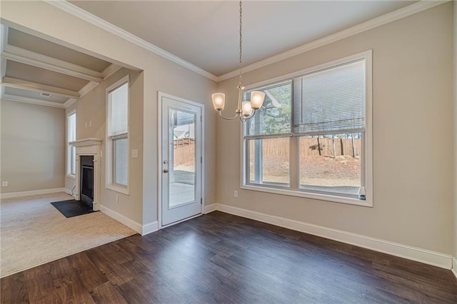 unfurnished dining area featuring crown molding, a notable chandelier, a fireplace with flush hearth, and baseboards