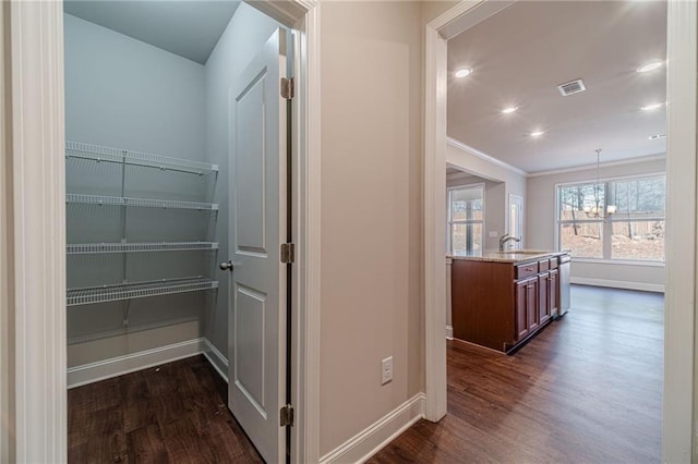 corridor with dark wood-style floors, a notable chandelier, and baseboards