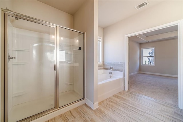 full bath featuring a shower stall, a garden tub, baseboards, and visible vents