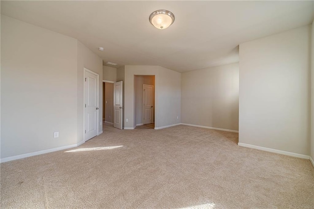 spare room with light carpet and baseboards