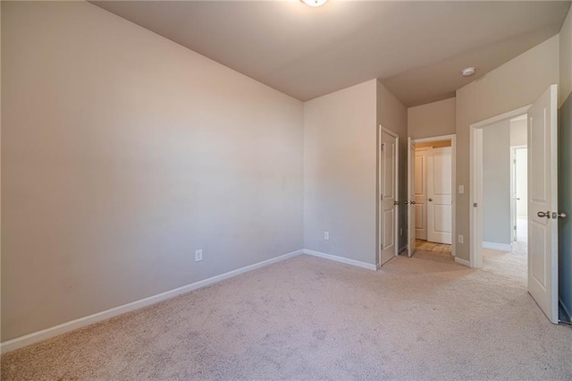 unfurnished bedroom with light carpet and baseboards