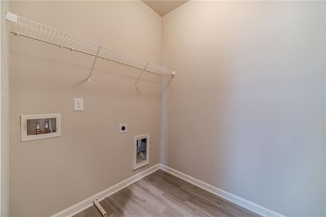 clothes washing area featuring electric dryer hookup, wood finished floors, baseboards, hookup for a washing machine, and laundry area