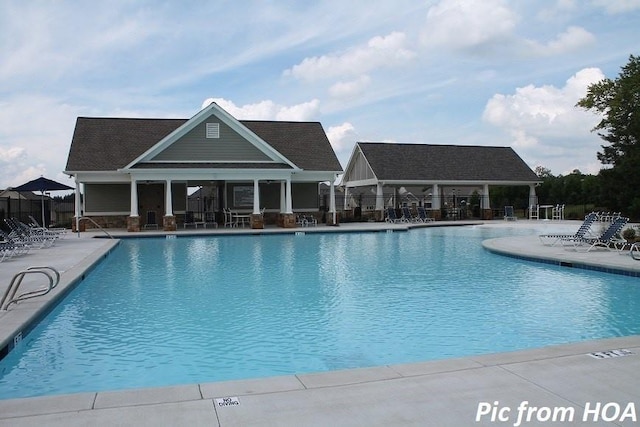 community pool with a patio area and fence