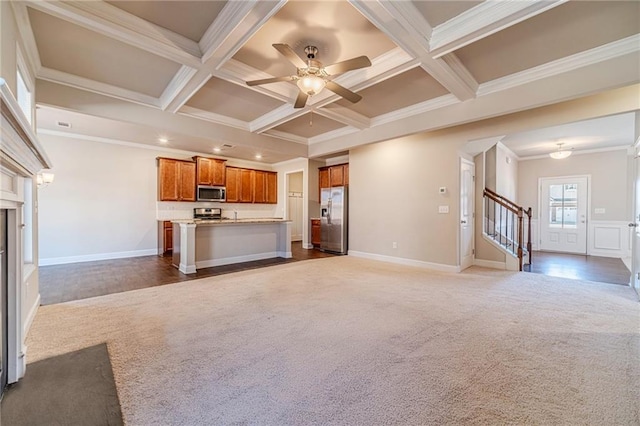 unfurnished living room with beamed ceiling, coffered ceiling, dark carpet, stairway, and a fireplace