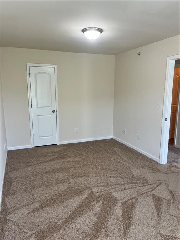 carpeted spare room with baseboards