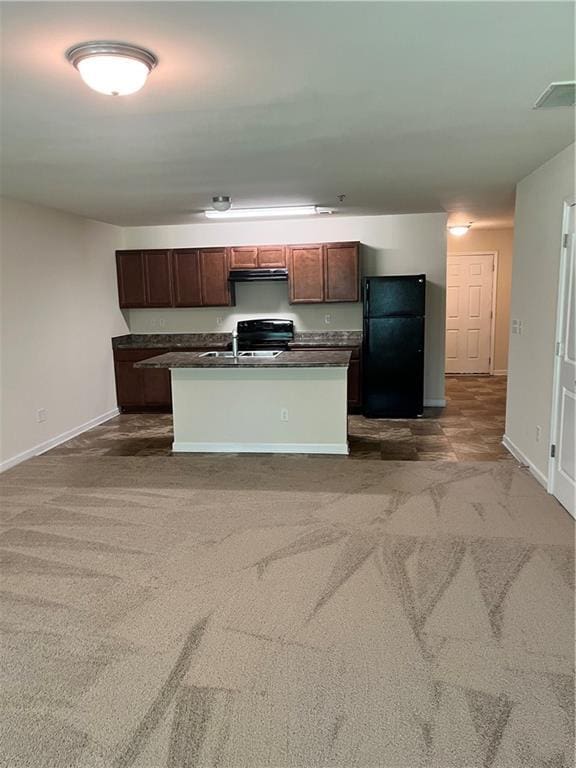 kitchen with baseboards, dark countertops, carpet flooring, and freestanding refrigerator