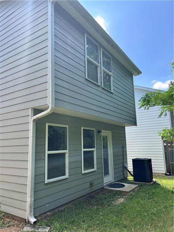 back of property featuring a yard and central air condition unit