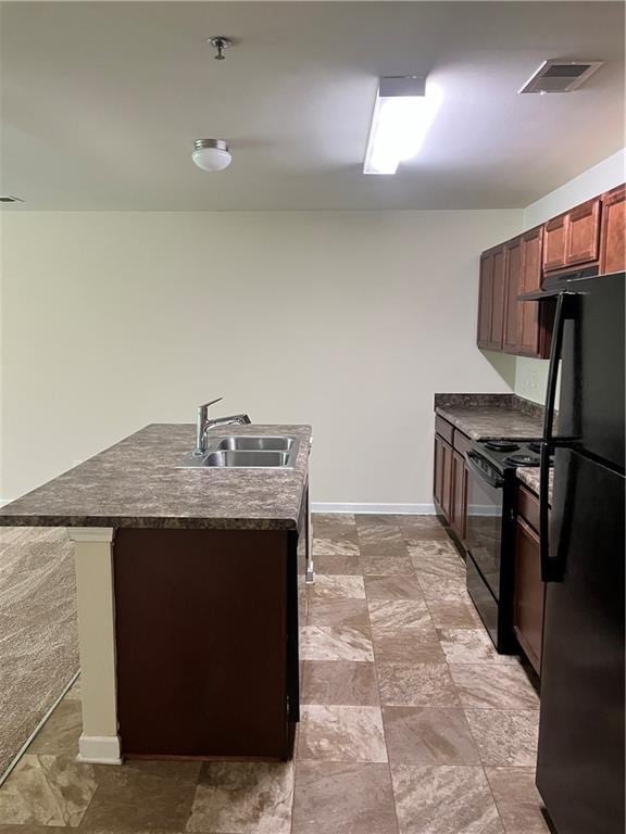 kitchen featuring black appliances, dark countertops, a sink, baseboards, and visible vents
