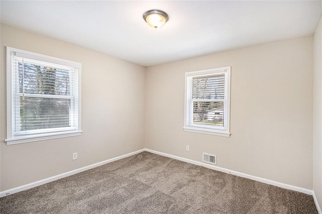 unfurnished room featuring visible vents, baseboards, and carpet