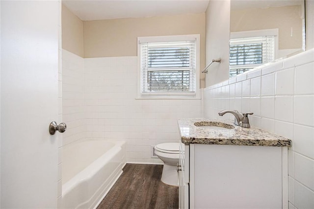 full bath with vanity, wood finished floors, wainscoting, tile walls, and toilet