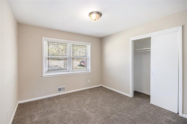 unfurnished bedroom with visible vents, baseboards, carpet, and a closet