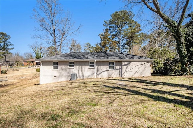 back of house featuring a yard, central AC unit, and brick siding