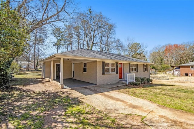 ranch-style house featuring a carport, driveway, a front lawn, and brick siding