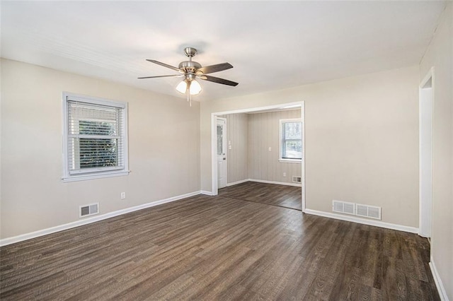 unfurnished room with dark wood-type flooring, baseboards, and visible vents