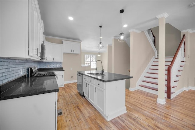 kitchen with sink, white cabinetry, a center island with sink, appliances with stainless steel finishes, and pendant lighting