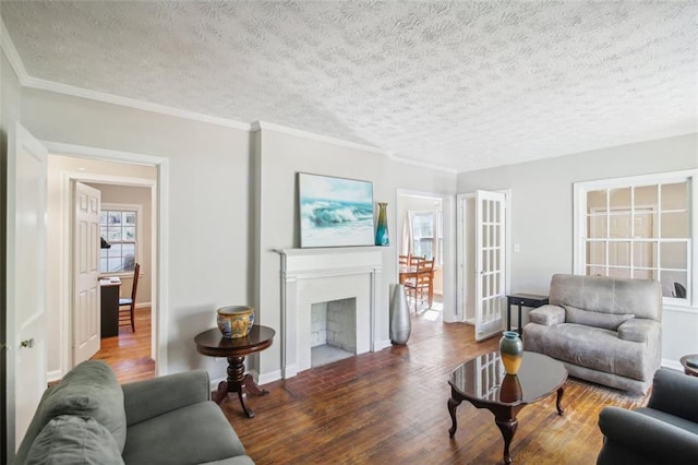 living room with hardwood / wood-style flooring, a textured ceiling, and ornamental molding