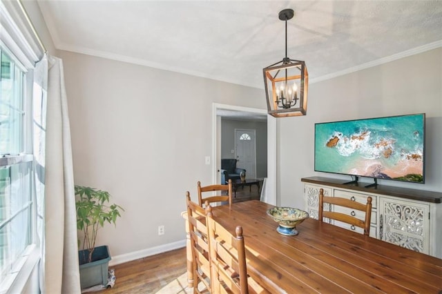 dining space with crown molding, hardwood / wood-style flooring, and a chandelier