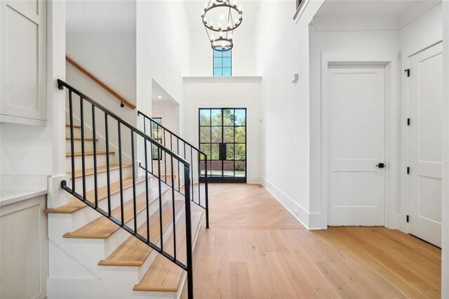 entrance foyer featuring light hardwood / wood-style flooring and a notable chandelier