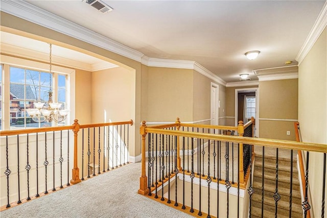 hallway with ornamental molding, carpet, visible vents, and a notable chandelier