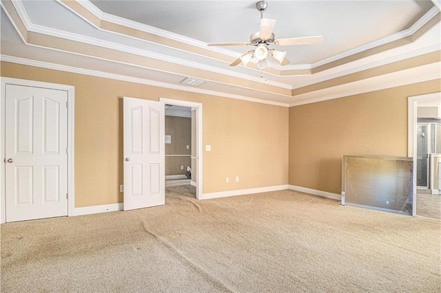 unfurnished bedroom featuring a tray ceiling, baseboards, visible vents, and carpet