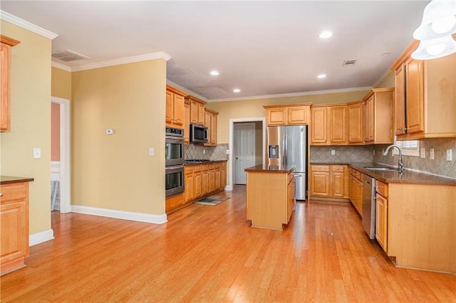 kitchen with stainless steel appliances, a sink, a kitchen island, ornamental molding, and light wood-type flooring