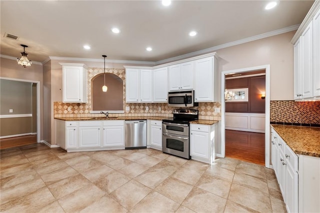 kitchen with sink, decorative light fixtures, white cabinets, and appliances with stainless steel finishes